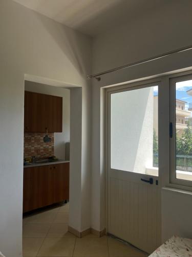 a room with a door and a kitchen with a window at Infinity room in Velipojë