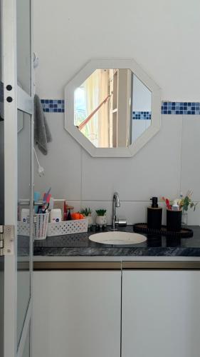 a white kitchen with a sink and a mirror at Miau de Pipa in Pipa