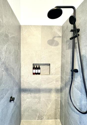 a shower with a shower head in a bathroom at Korora's Haven Coffs Harbour in Kororo Basin