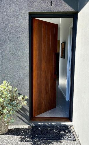 a wooden door with a mirror on the side of a building at Korora's Haven Coffs Harbour in Kororo Basin