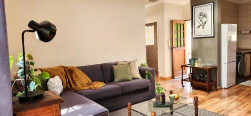 a living room with a purple couch at Modern retro private apartment in Polokwane