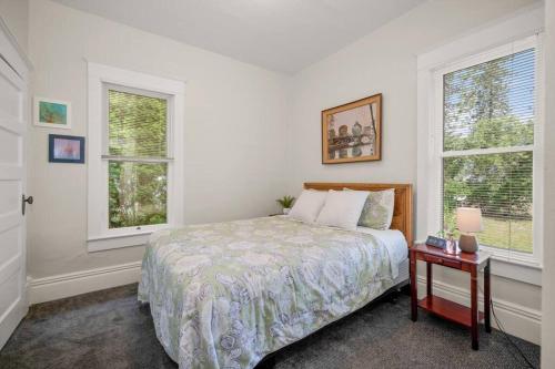 a bedroom with a bed and two windows at Chic Vintage Vibes Stylish Stay Near It All in Spokane