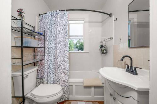 a bathroom with a toilet and a sink and a window at Chic Vintage Vibes Stylish Stay Near It All in Spokane