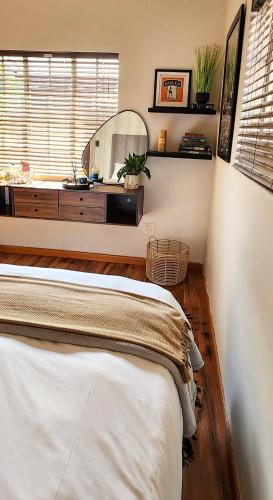 a bedroom with a bed and a large mirror at Modern retro private apartment in Polokwane