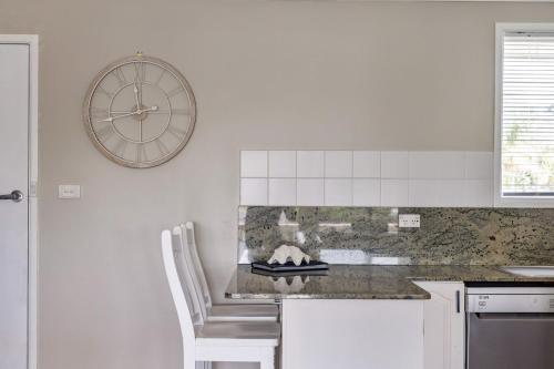 a kitchen with a counter and a clock on the wall at Ocean Vibes in Scotts Head