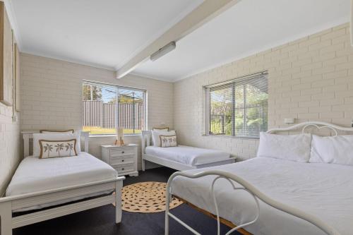 a bedroom with two beds and two windows at Ocean Vibes in Scotts Head