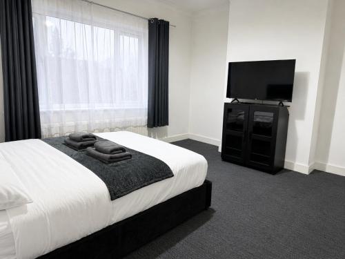 a bedroom with a bed and a flat screen tv at Private Flat Near City Centre in Peterborough