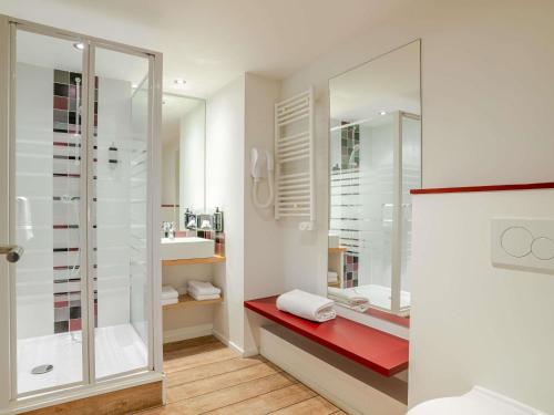 a bathroom with a shower and a red bench at ibis Styles Saint-Jean-de-Luz Donibane in Saint-Jean-de-Luz