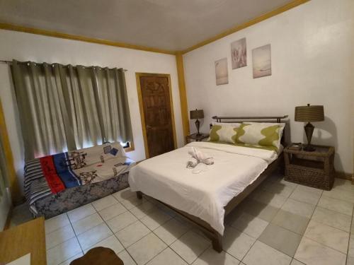 a bedroom with a large bed and a window at Danao RM House in Idanao