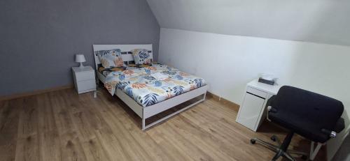 a bedroom with a bed and a desk and a chair at Belle chambre 2 in Seraing