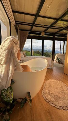 a white bath tub sitting on the floor in a room at Morada do Valle Chalés in Timbe do Sul