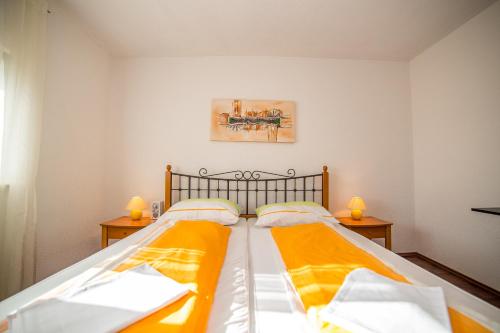 a bedroom with two beds with orange sheets at Apartments Kati in Omiš