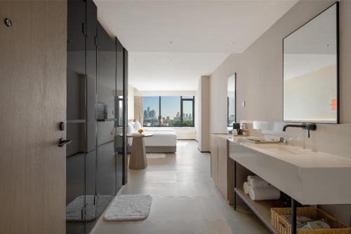 a bathroom with a sink and a couch in a room at SOVIS PLUS HOTEL in Shenzhen