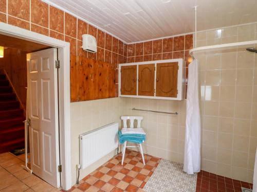 a small bathroom with a chair and a shower at Forest View in Teeranearagh