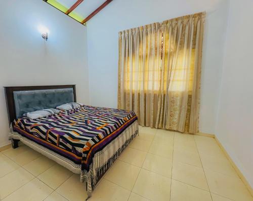 a bedroom with a bed in a room with a window at Senu Bungalow in Ragama