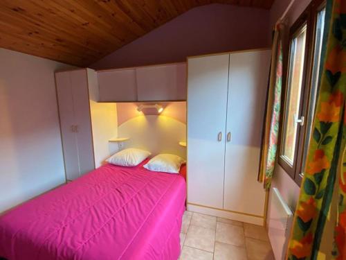 a bedroom with a pink bed and a cabinet at Maison avec animaux admis - 4 pers. - API-1-52-2864 in Saint-Rome-de-Tarn