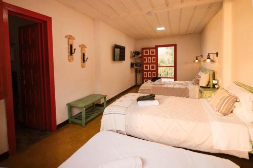 a bedroom with two beds and a red door at San Remo Ecolodge in Santa Rosa de Cabal