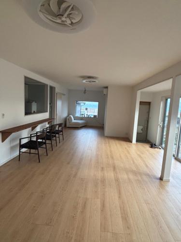 an empty living room with a table and chairs at Bluebase 波音 in Goto