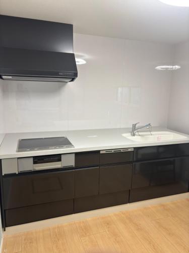 a kitchen with a sink and a stove at Bluebase 波音 in Goto