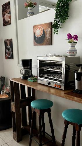 a kitchen with a counter with two stools at Mírame Canarias in Vecindario