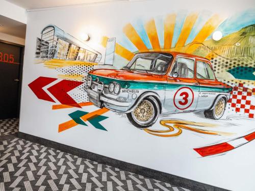 a wall with a painting of a car on it at ibis Styles Neckarsulm in Neckarsulm