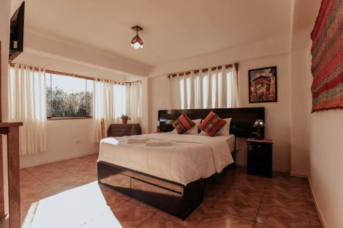 a bedroom with a large bed and a window at Piedra Wasi Ecolodge Urubamba in Urubamba