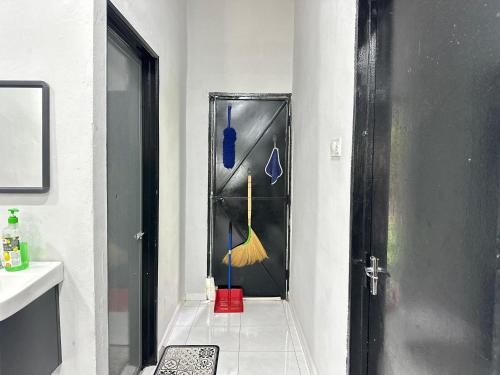 a bathroom with a black door and a sink at Aden's Stopover House in Kuala Nerang