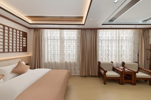 a bedroom with a bed and a desk and curtains at Dali Classical Rosewood Boutique Inn in Dali