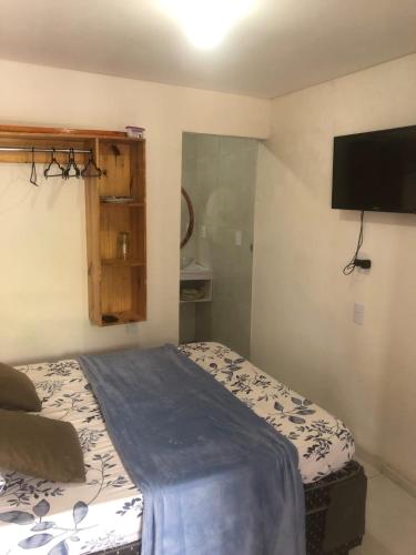 a bedroom with a bed and a flat screen tv at Pousada da Neném - Quarto Tangerina in Campina Grande
