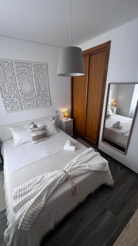 a bedroom with a large bed with a large mirror at Zen Terrace Townhouse in Faro