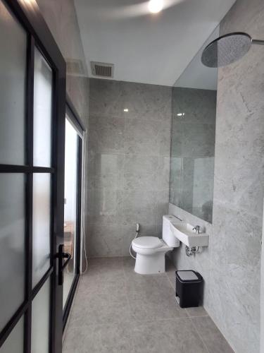 a bathroom with a toilet and a sink and a window at Poshaka Karimunjawa in Karimunjawa