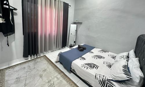 a bedroom with a bed with a black and white blanket at Aden's Stopover House in Kuala Nerang