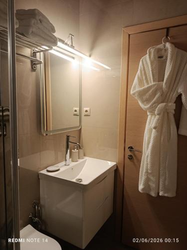 a white bathroom with a sink and a mirror at VueSurMer Amarynthos in Amarynthos