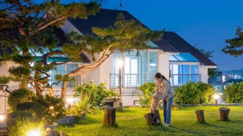 a woman standing in front of a house at Daebu-do, White Island Pension in Ansan