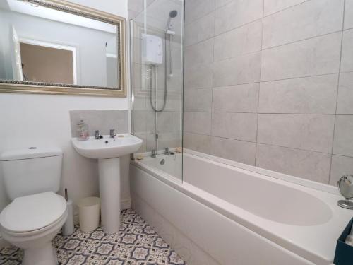 a bathroom with a toilet and a sink and a shower at Bluebell Cottage in Selby