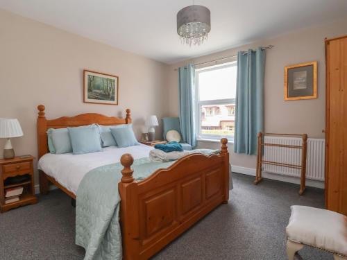 a bedroom with a large bed and a window at Bluebell Cottage in Selby