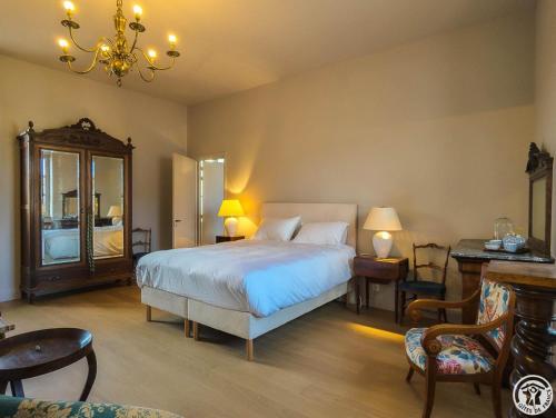 a bedroom with a bed and a table and chairs at La villa saviesa in Cazères