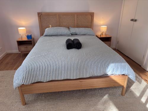 a bedroom with a bed with a pair of shoes on it at The Perch in Nornalup