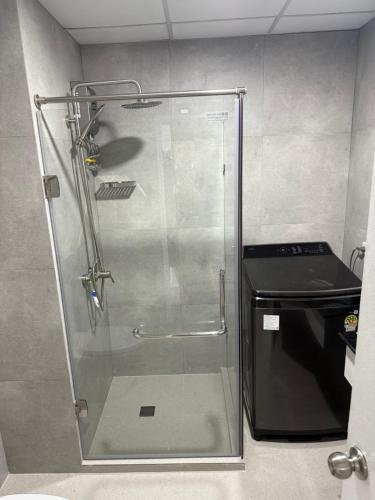 a shower with a glass door in a bathroom at New world condo1802 in Rayong