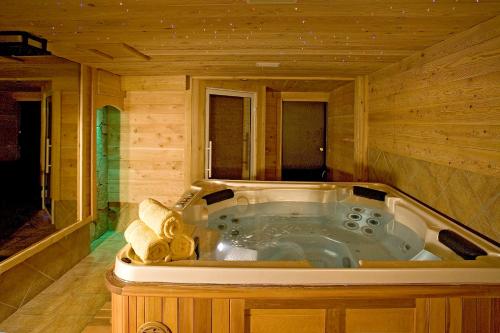 una bañera de hidromasaje en una cabaña de madera en Village Vacances Passion Les 4 Saisons Resort & Spa en Saint-Chaffrey