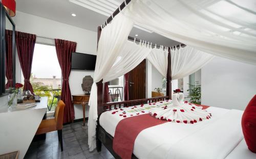 a bedroom with a bed with red roses on it at Boutique Indochine d'Angkor in Siem Reap