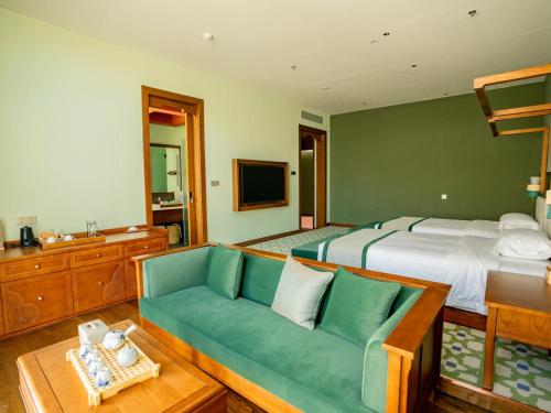 a bedroom with a bed and a green couch at Shigatse Summer Palace Healing Hotel in Shigatse