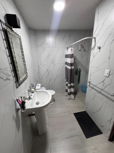 a white bathroom with a sink and a shower at Havana House in Mexico City