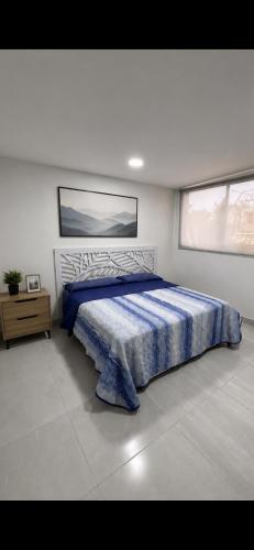 a bedroom with a bed with a blue comforter at Havana House in Mexico City