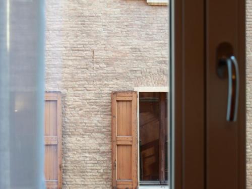 a brick building with two windows and a door at Casa Isolani Luxury Rooms Piazza Maggiore in Bologna