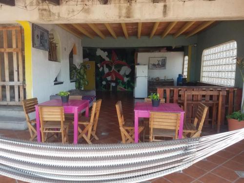 a patio with pink tables and chairs and a kitchen at hostal la playa vallarta in Puerto Vallarta