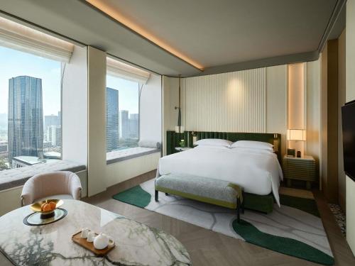 a bedroom with a large bed and a large window at Fairmont Xiamen in Xiamen