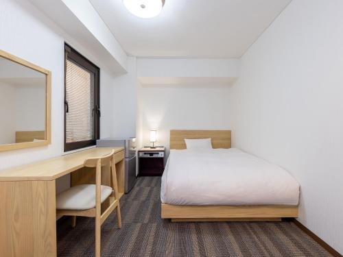 a bedroom with a bed and a desk and a desk at Hotel Neo Rouge in Tokyo