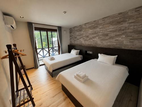 a hotel room with two beds and a window at CoCo Town Goryu in Hakuba
