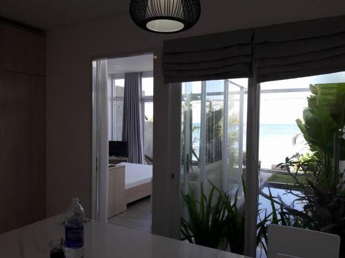 a room with a view of a bedroom with a balcony at TS Beach House in Phu Quoc